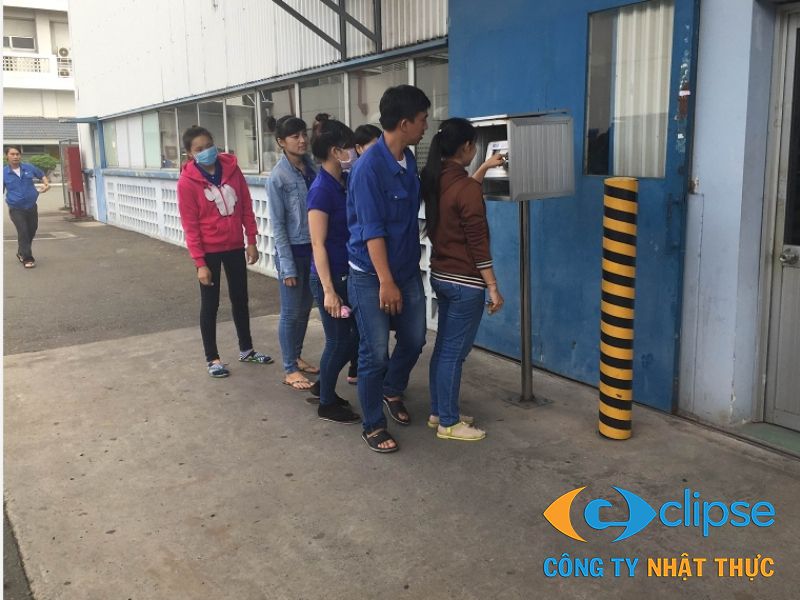 Công nhân thực hiện chấm công bằng khuôn mặt nhanh chóng tại lối ra vào xưởng.